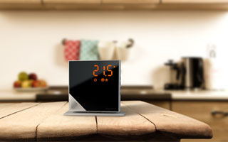 Termostato digital inteligente Momit sobre la mesa de una cocina